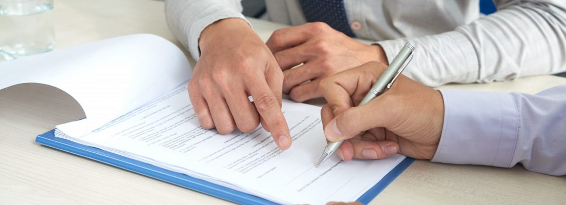Businessman showing his partner where to sign the contract